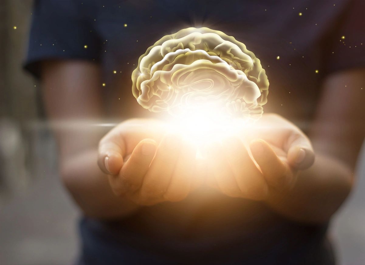 Glowing brain held in cupped hands.